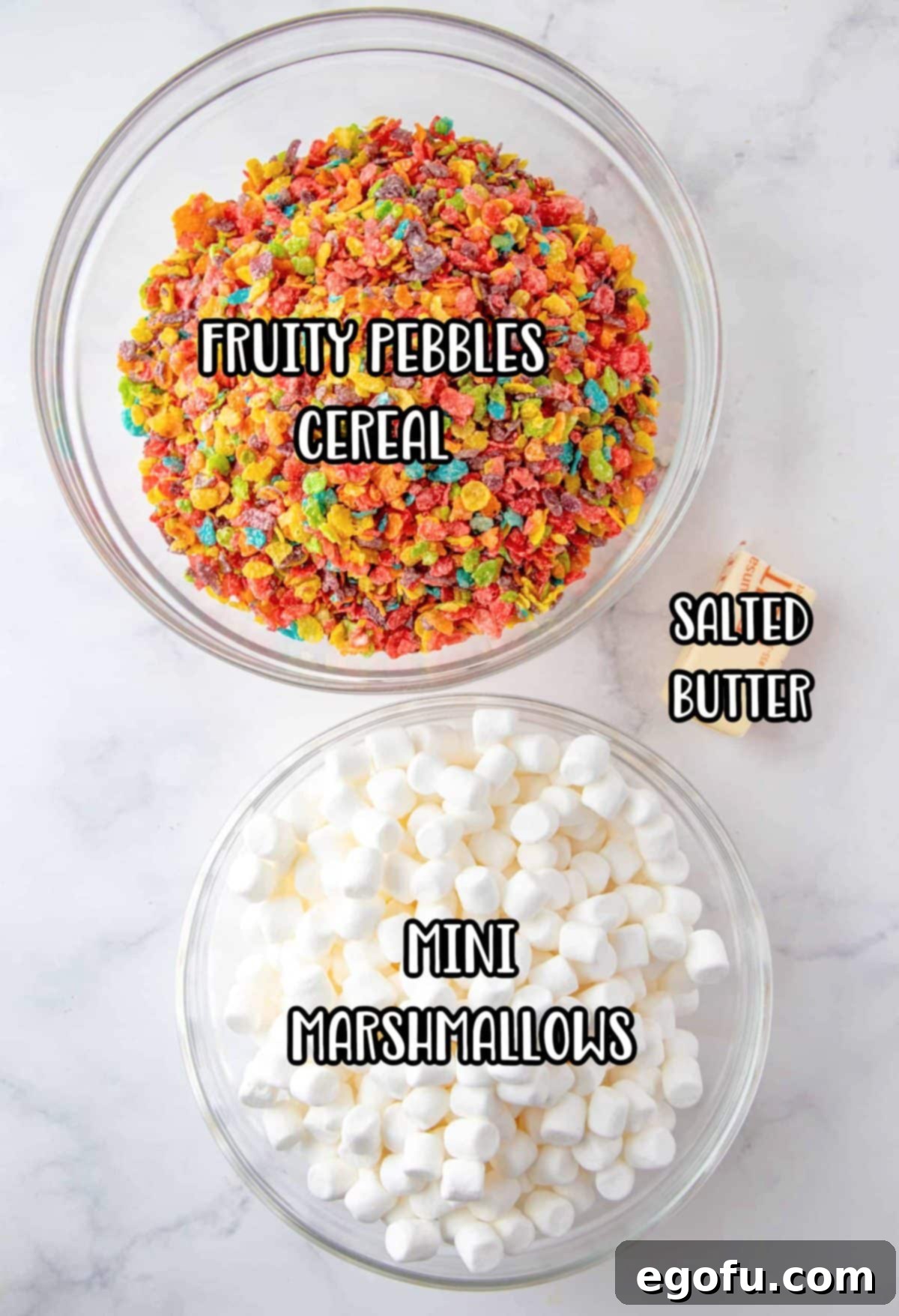 A flat lay image showing the three essential ingredients: Fruity Pebbles cereal, mini marshmallows, and salted butter.