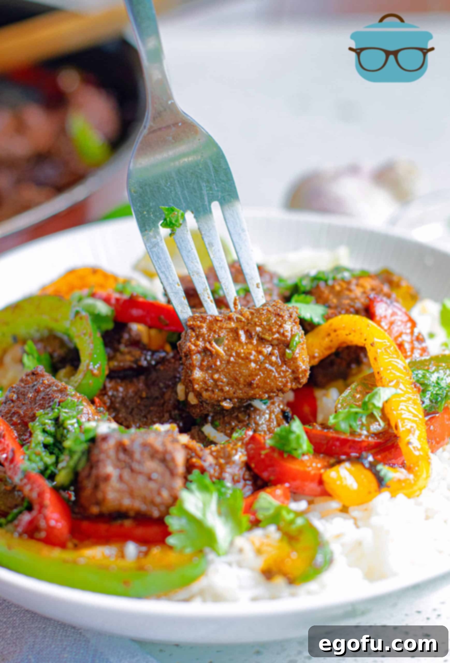 Fork holding up a piece of steak in Steak Bite Fajita Bowls