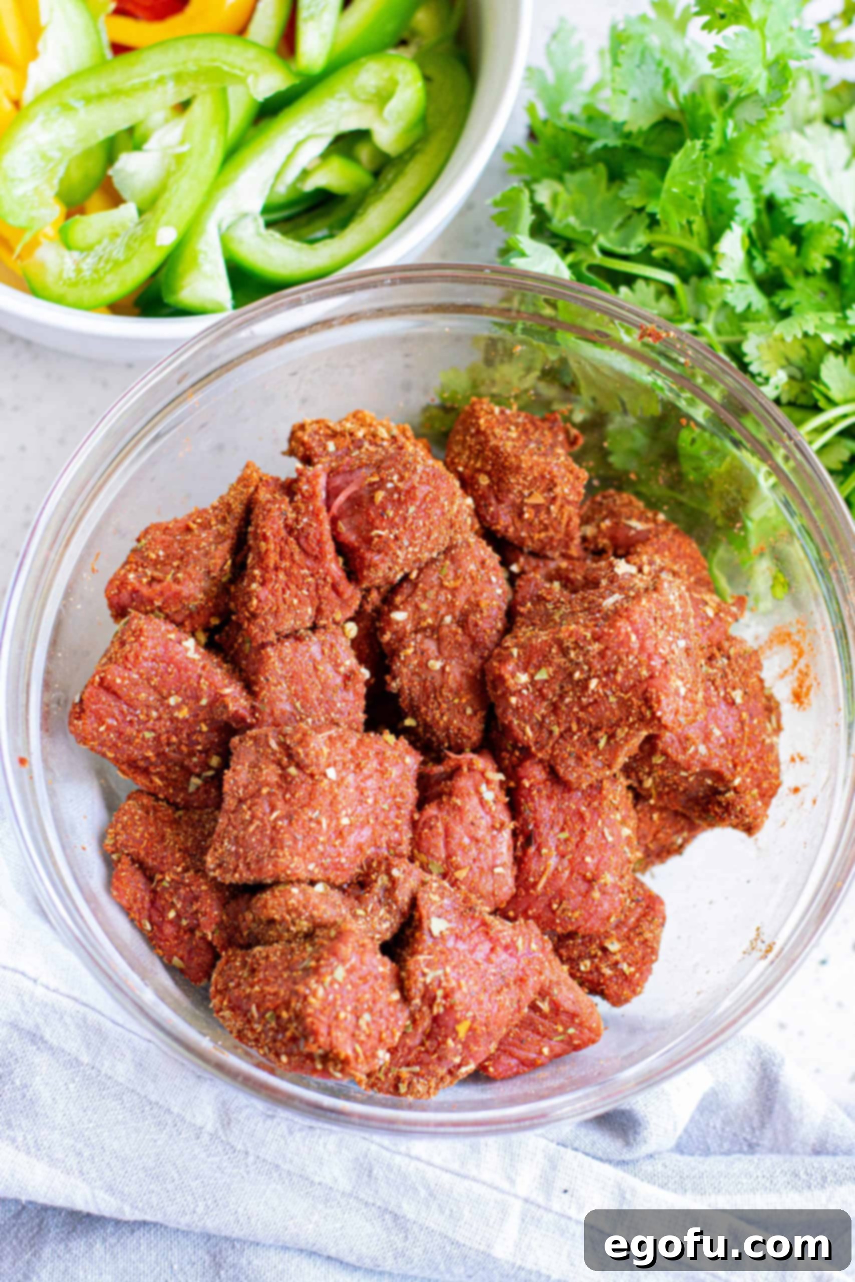 Steak bites coated in seasonings in a bowl.