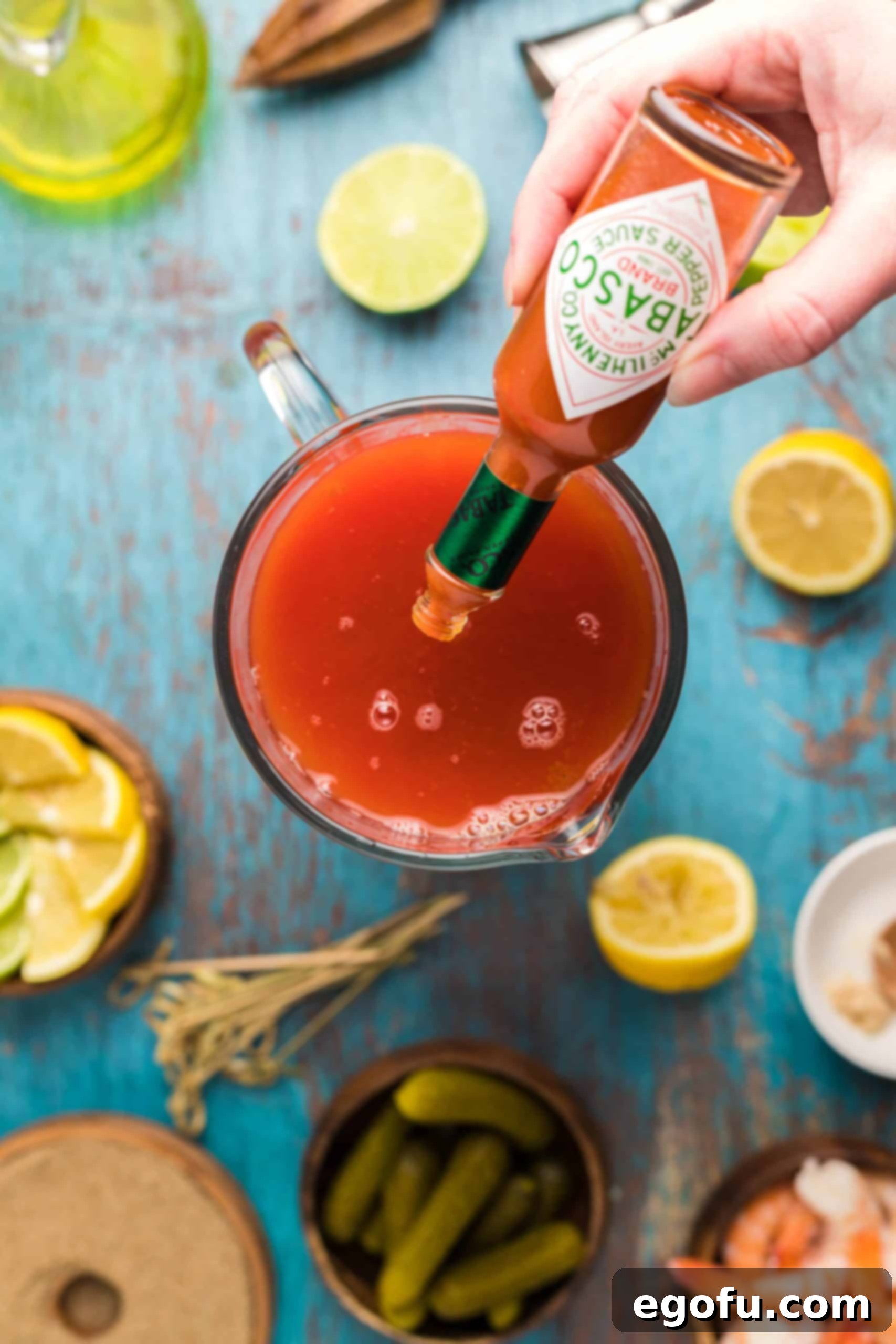 Signature Bloody Mary Blend 10 Hot sauce being addd to Bloody Mary Mix in pitcher.