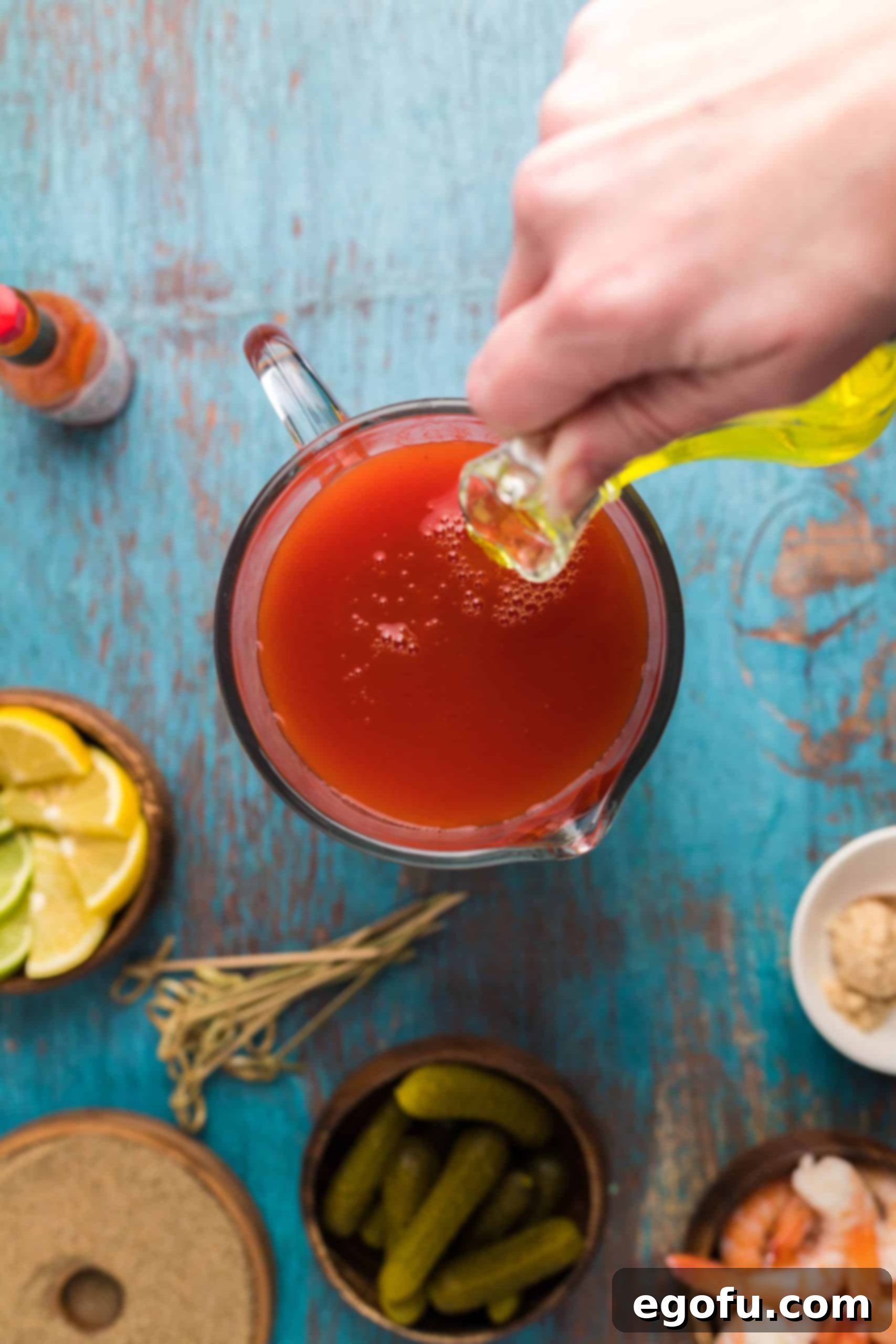 Signature Bloody Mary Blend 5 Pickle juice being poured into pitcher.