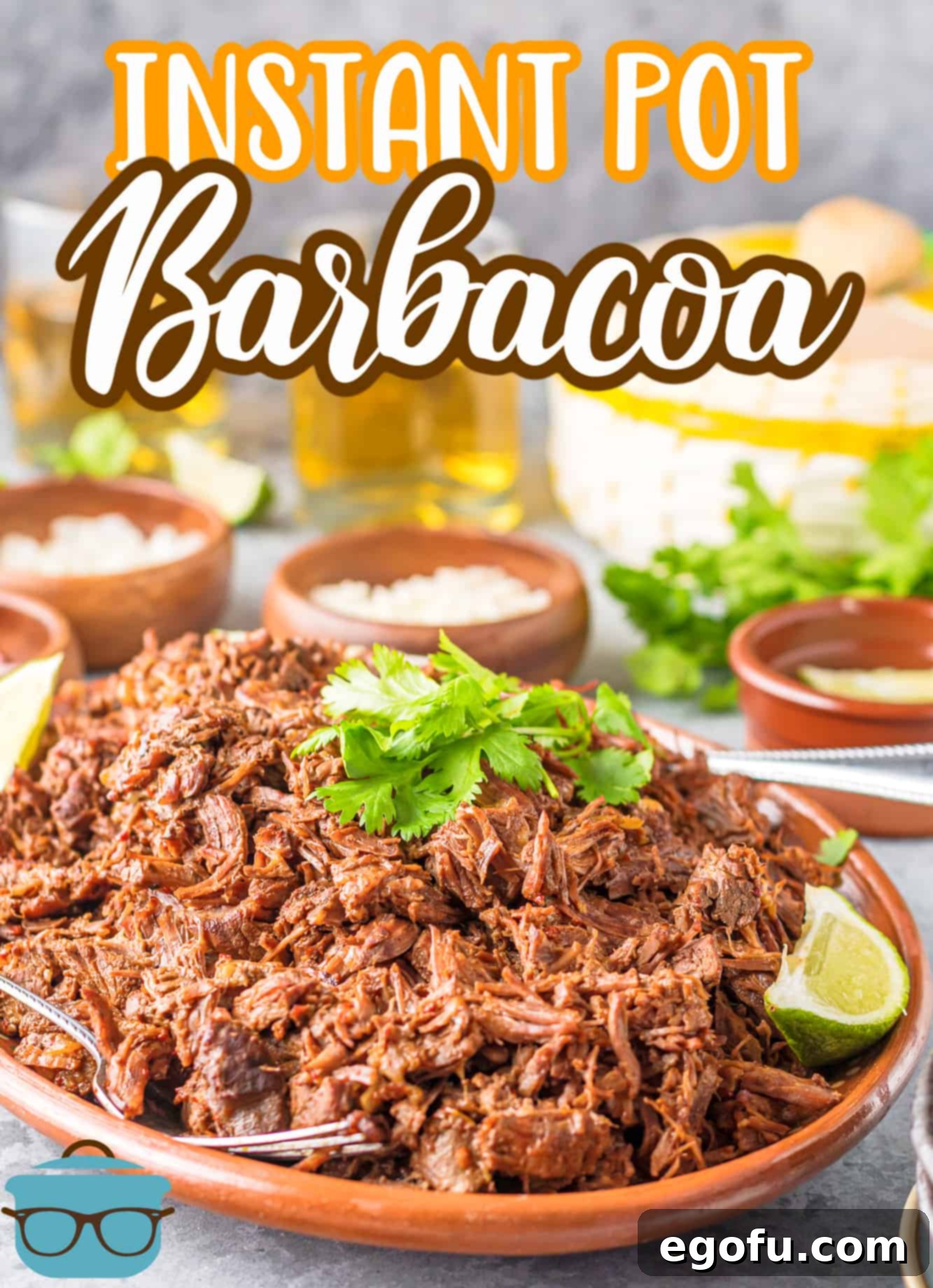 Platter of Instant Pot Barbacoa garnished with fresh lime wedges and cilantro, ready to serve.