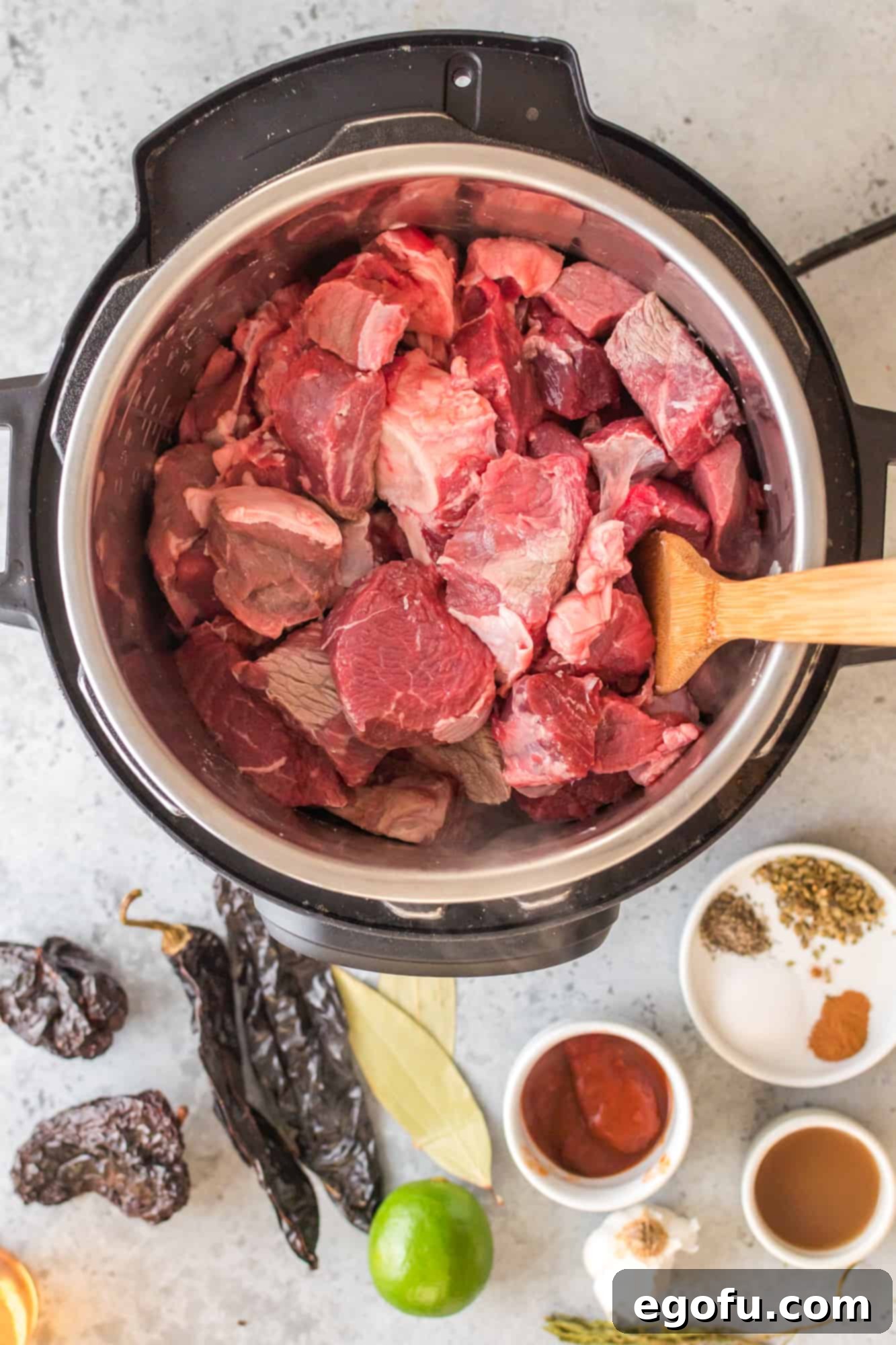Diced beef chunks being seared in the Instant Pot on saute mode.
