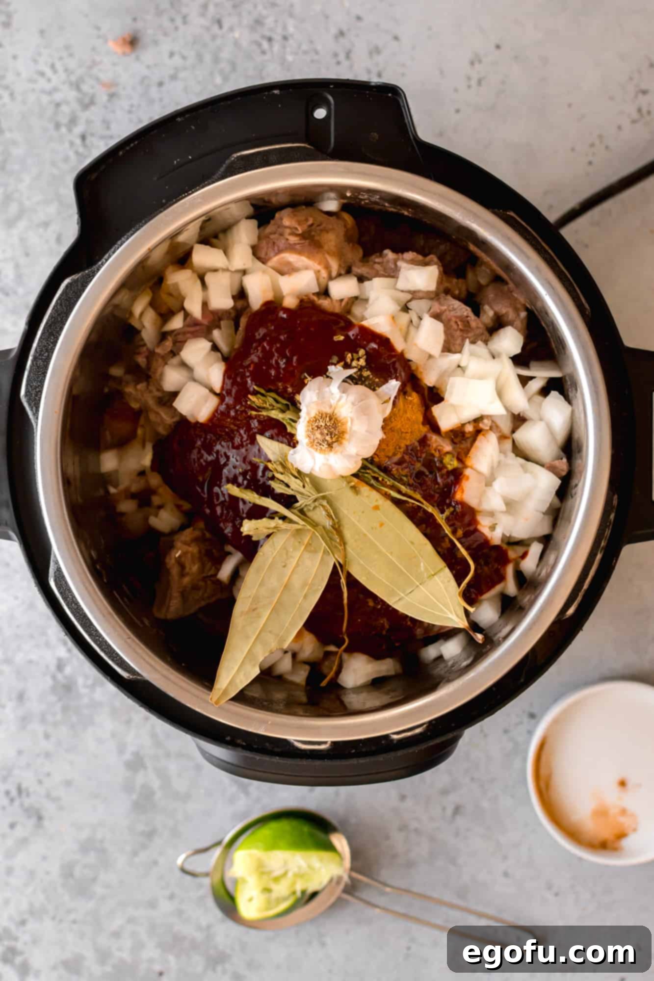 Sliced garlic and beer added to the Instant Pot, layered over the meat and sauce.