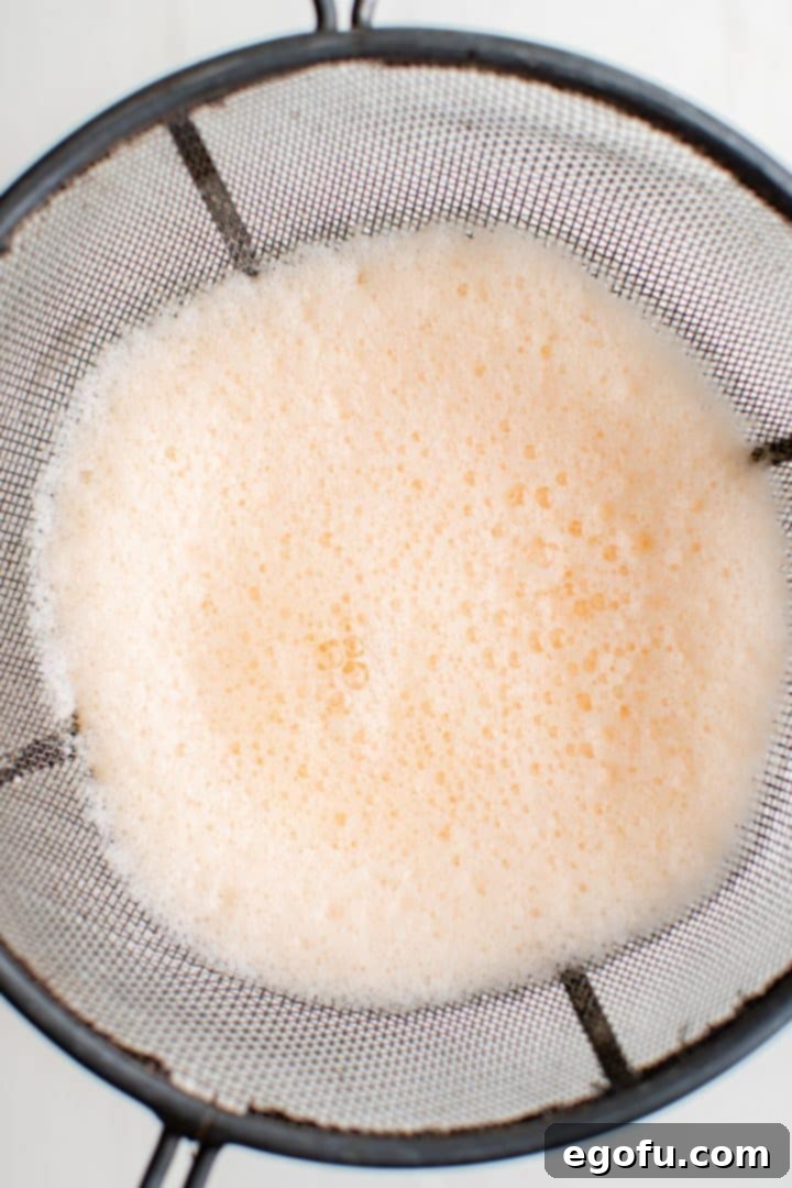 Melon Breeze 7 Drink being strained through fine mesh strainer