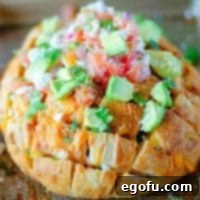 Square image of finished and garnished Taco Pull Apart Bread on baking sheet, looking vibrant and delicious.