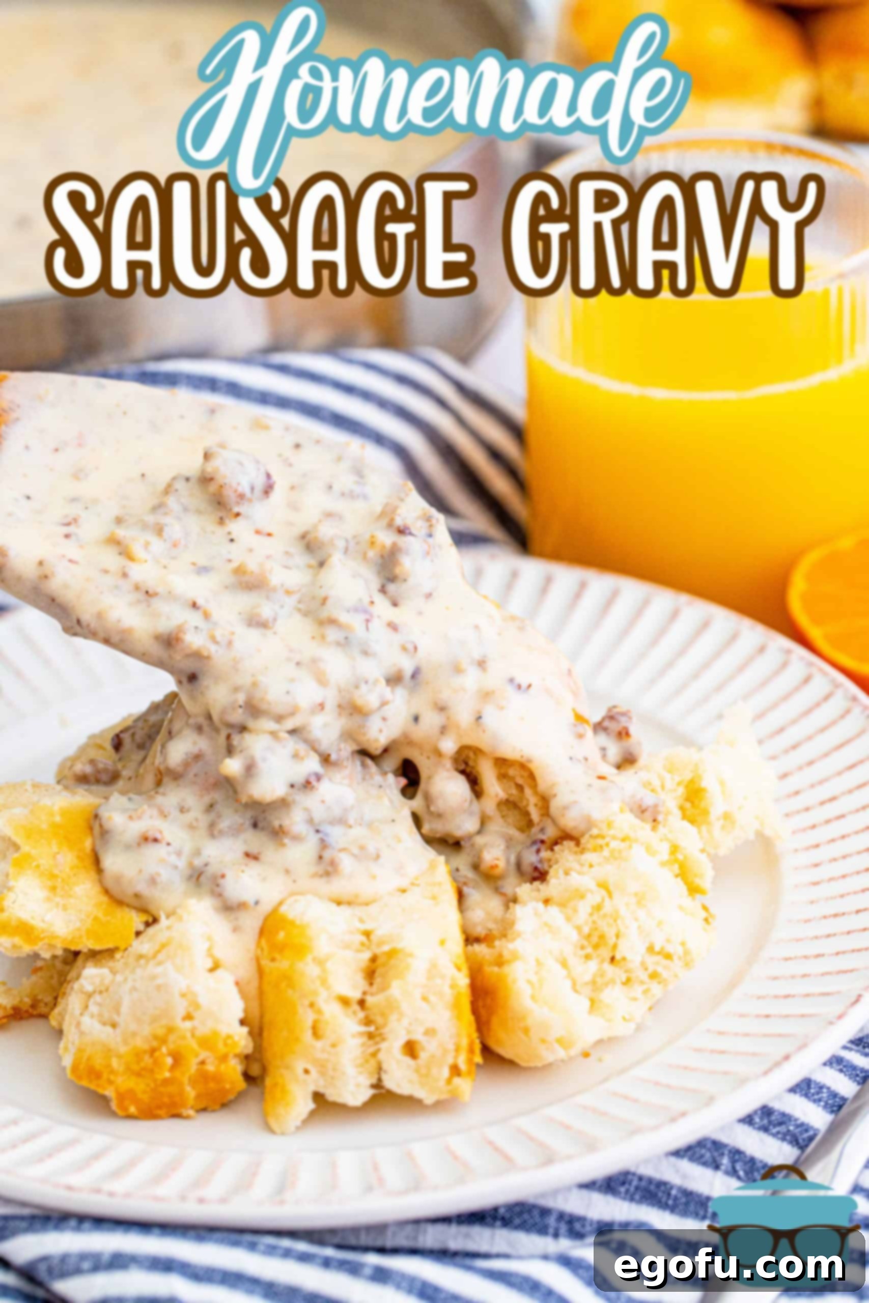 Homemade sausage gravy being spooned over biscuits on a white plate, ready to be served for breakfast.