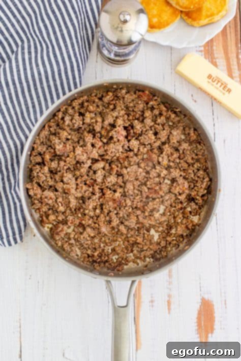 Cooked sausage in metal pan with striped linen