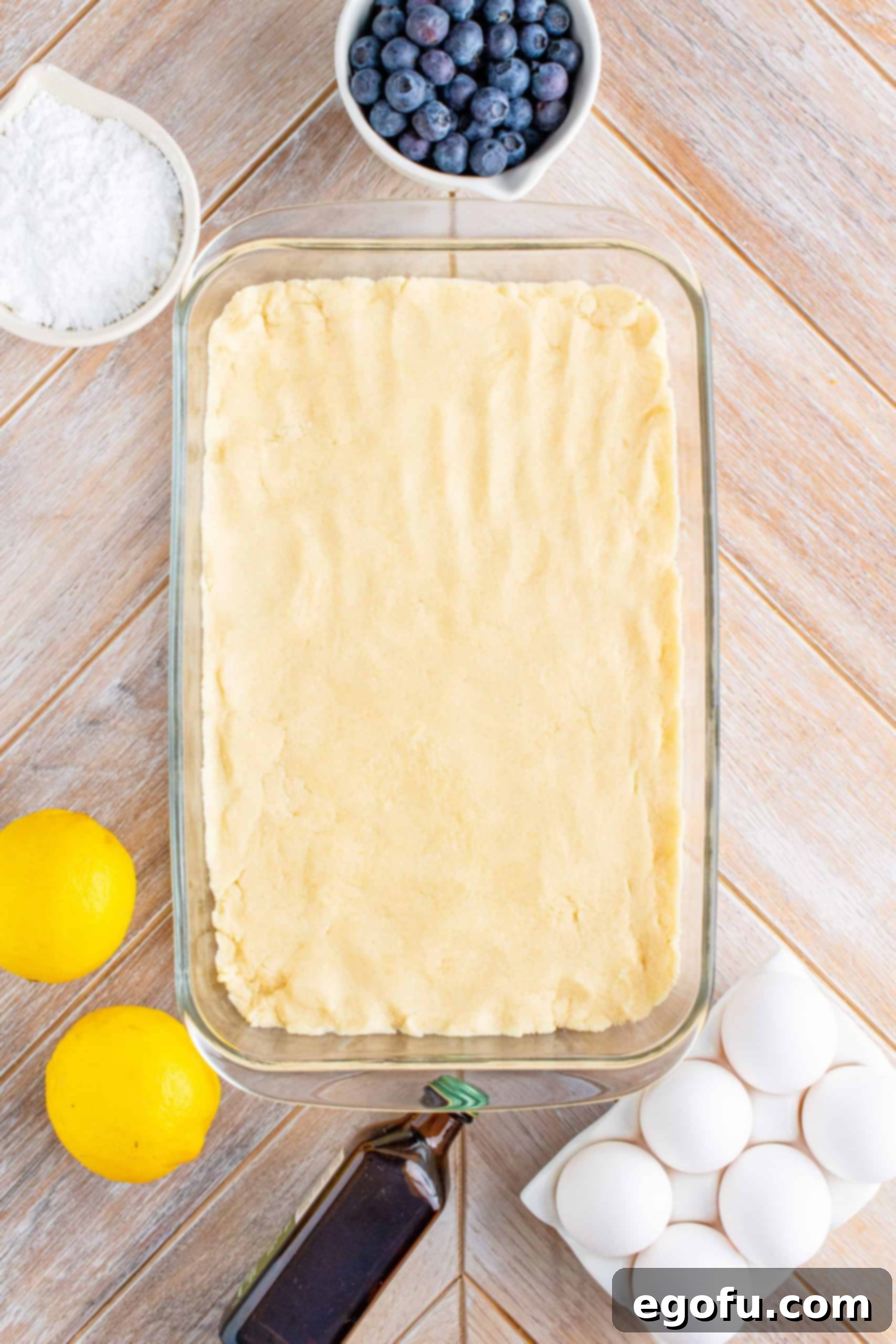 Crust mixture evenly pressed into the prepared baking dish, ready for baking.