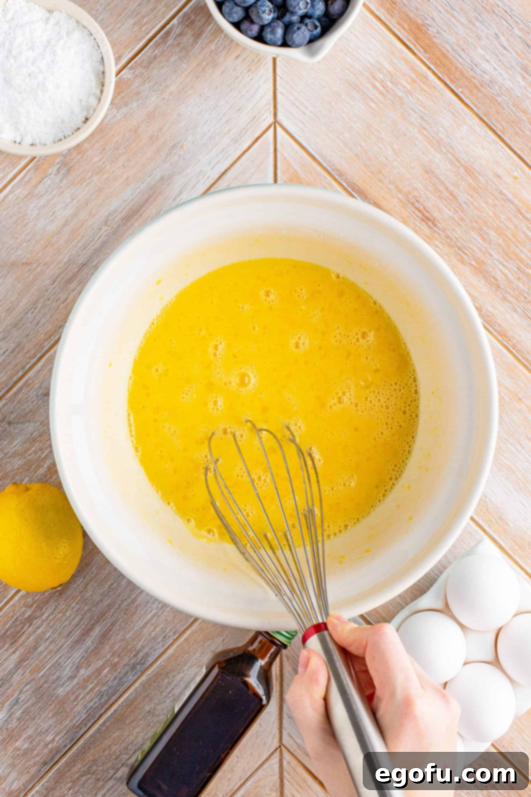 The smooth, whisked lemon filling mixture in a white bowl.