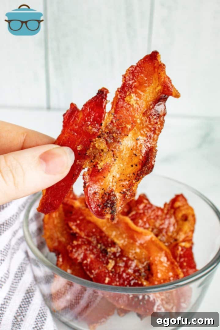 Hand holding up piece of Pig Candy from clear bowl.