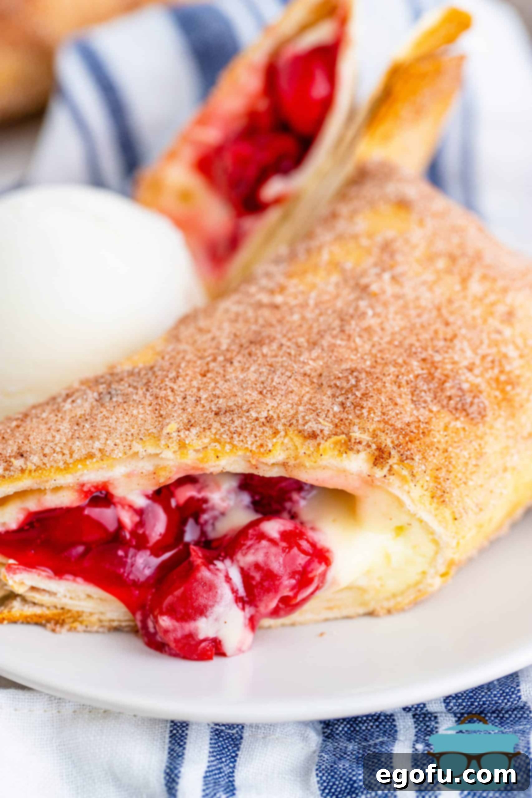 Air Fryer Cheesecake Chimichanga on plate cut open showing cherry cheesecake filling.
