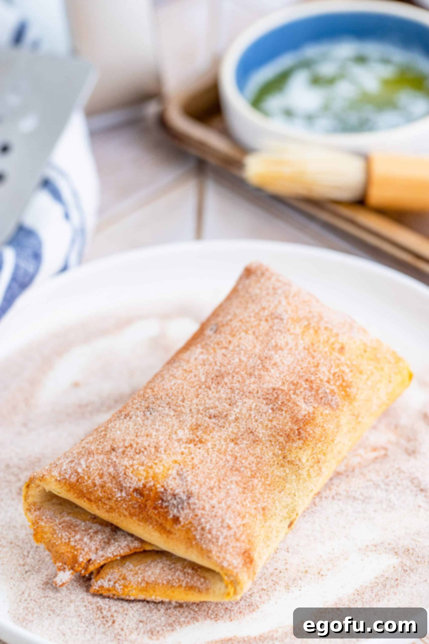 Finished chimichanga being rolled in cinnamon sugar mixture.
