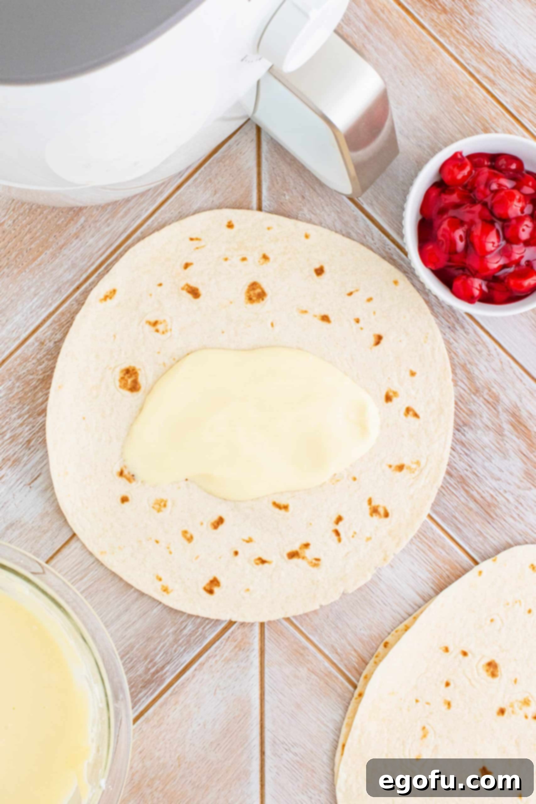 Tortilla with some cheesecake filling spread down center.