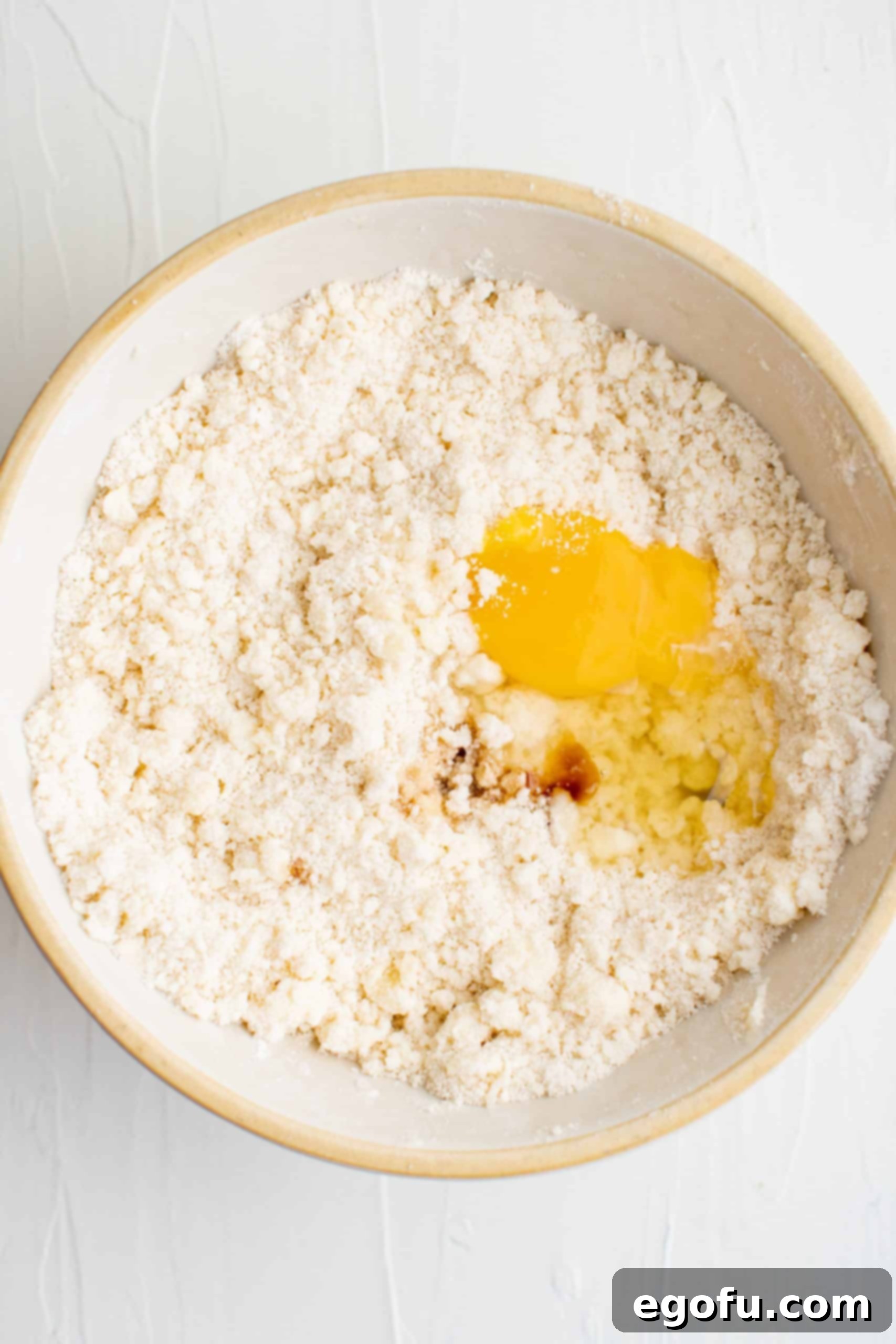 Golden Cherry Crumble Bars 6 Beat flour and butter mixture in bowl with egg and vanilla added.