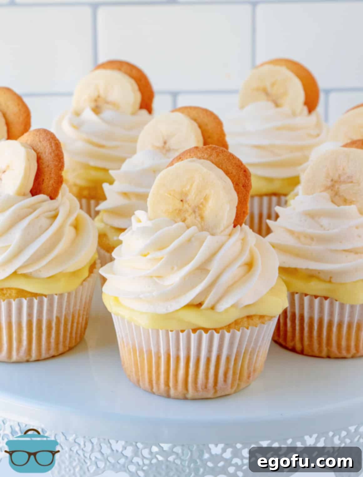 Velvet Banana Delight Cupcakes 21 A display of perfectly frosted and garnished Banana Pudding Cupcakes on an elegant cake stand.