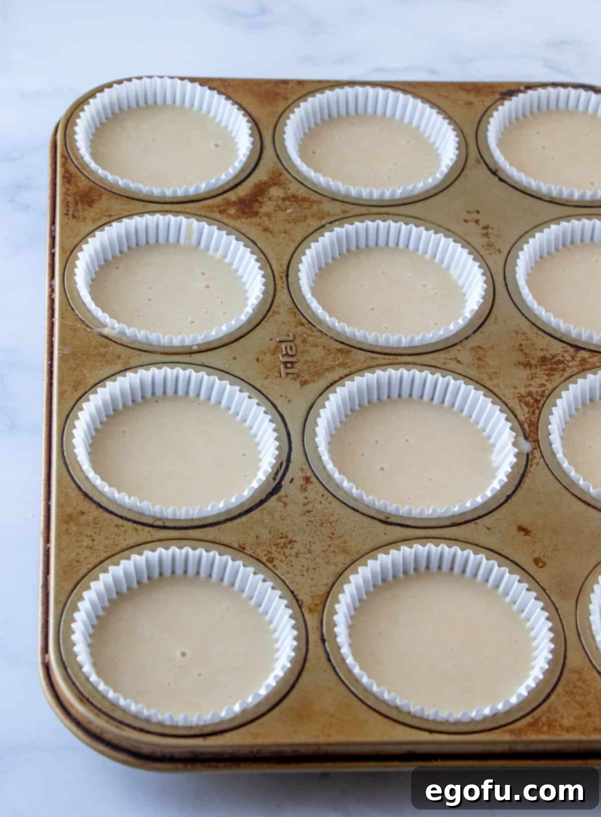 Velvet Banana Delight Cupcakes 8 Cupcake liners filled two-thirds full with fresh cupcake batter, ready for baking.