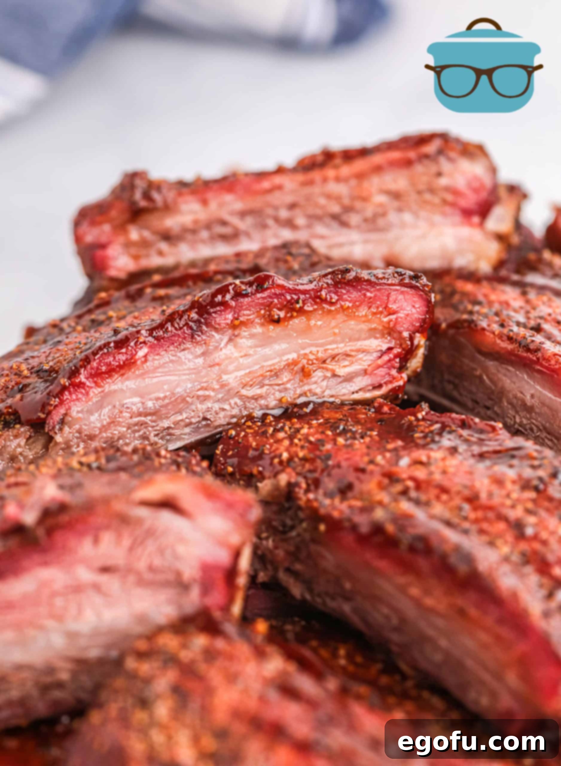 Slow-Smoked Beef Ribs 2 Stacked Smoked Beef Ribs on top of one another close up showing smoke ring.