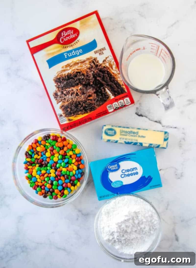 Ingredients needed for M&M Brownie Batter Dip: brownie mix, milk, butter, cream cheese, powdered sugar and mini M&M's arranged for clarity.