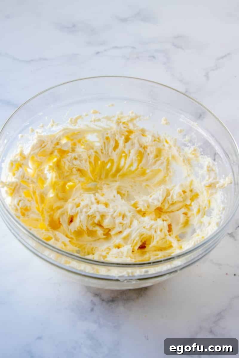 Butter and cream cheese beaten together to a smooth consistency in a clear bowl.