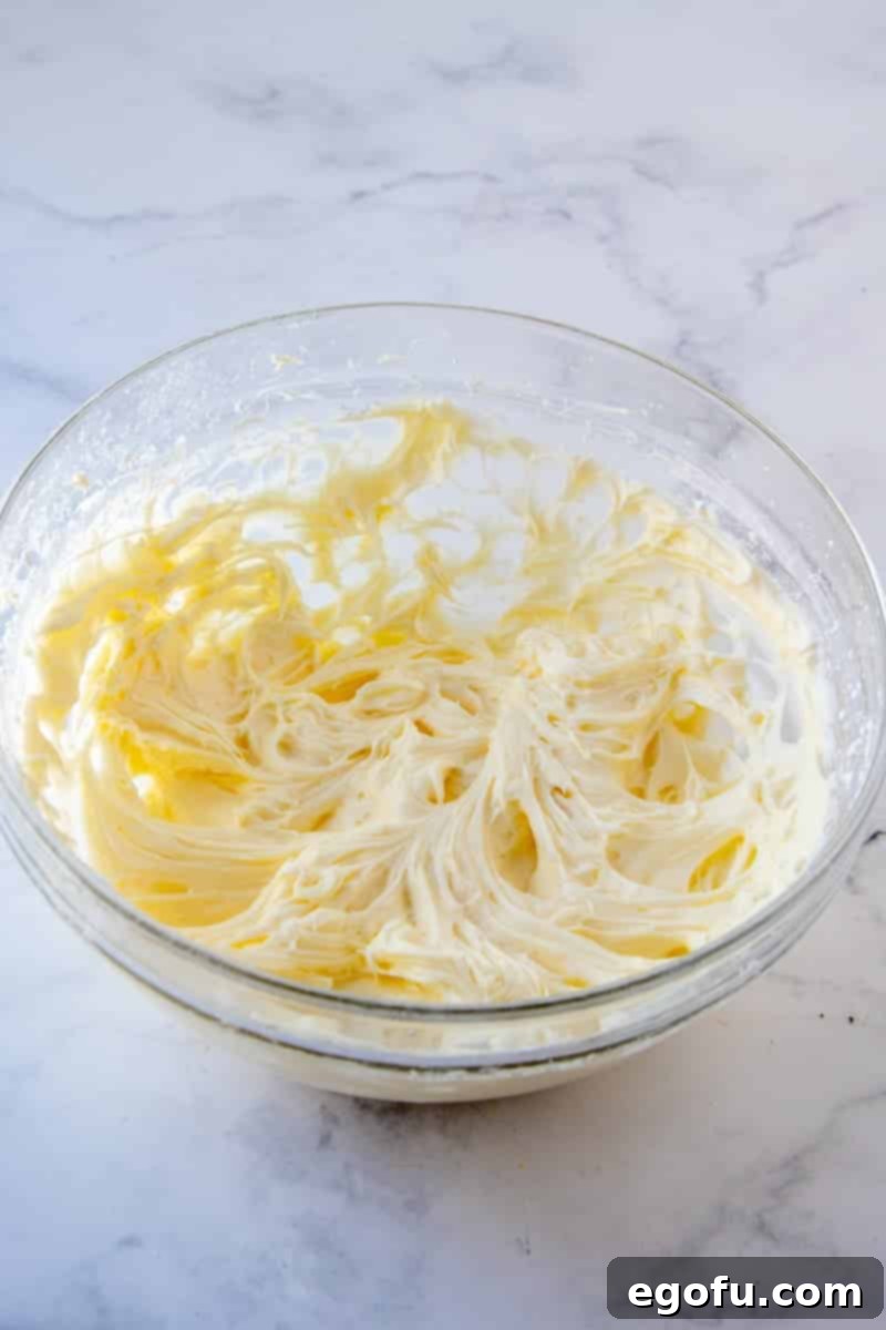 Powdered sugar fully blended into the butter and cream cheese mixture, creating a smooth base.