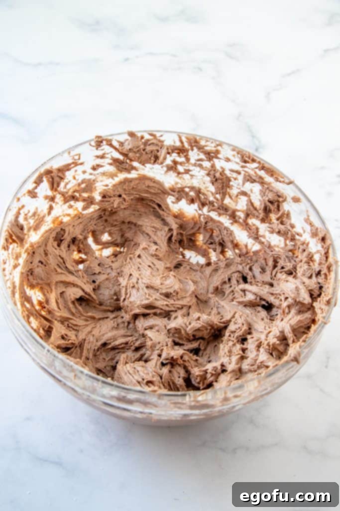 Brownie mix fully beaten into the butter and cream cheese mixture, forming the core of the dip.