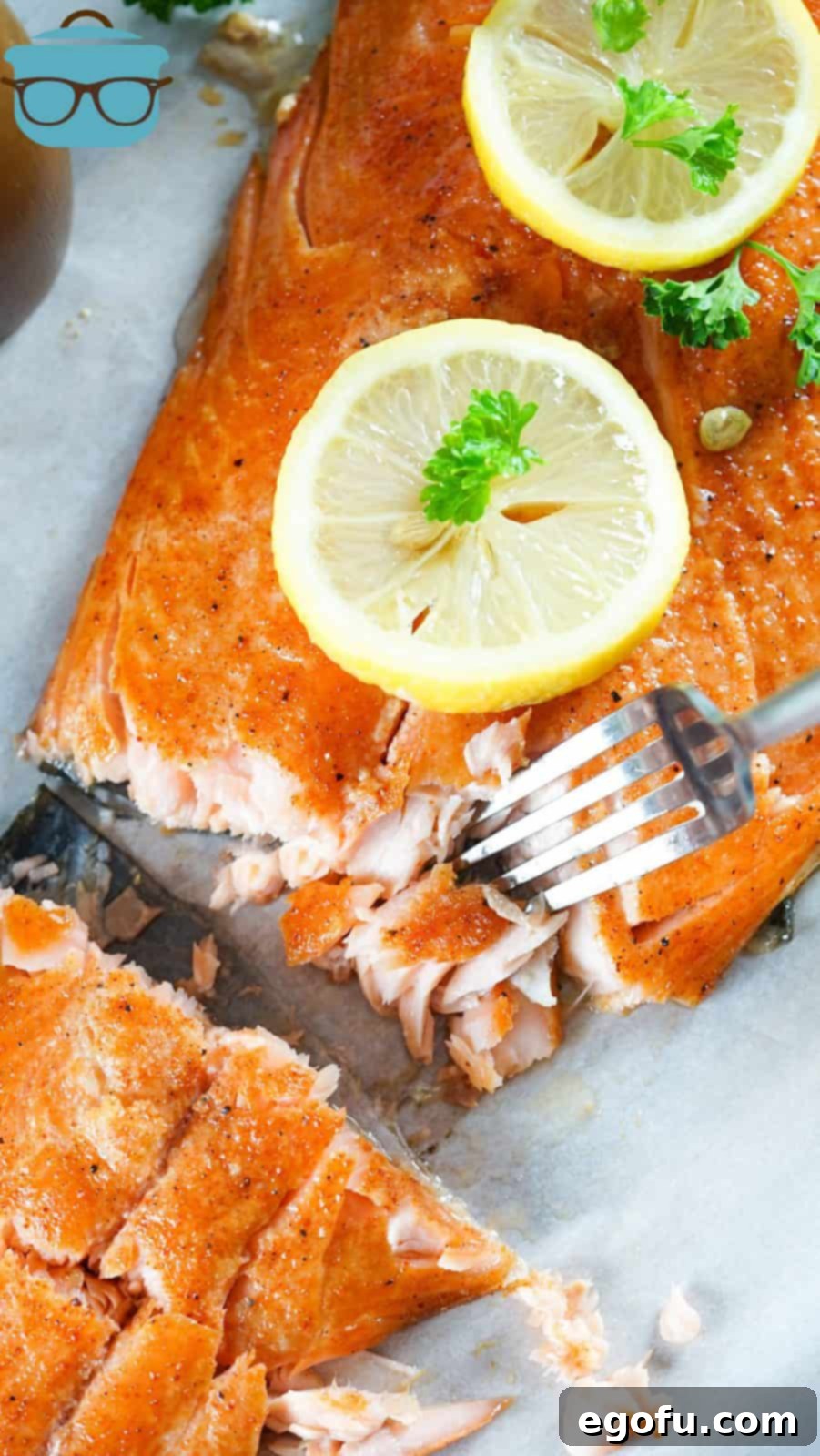 Overhead of finished Smoked Salmon with lemons and fork going into salmon