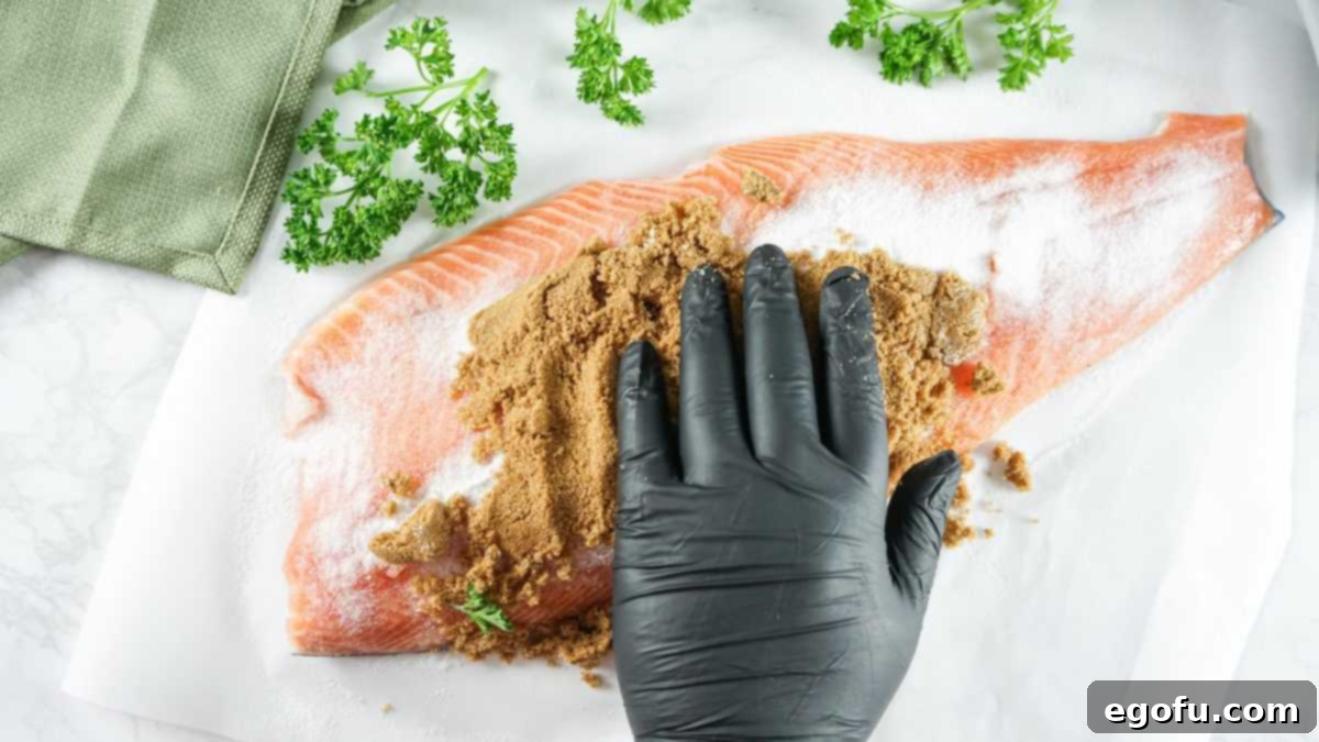 Brown sugar being rubbed over the salt on salmon