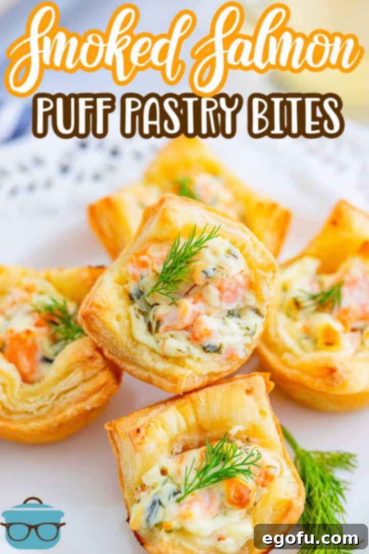Stacked Smoked Salmon Puff Pasty Bites on a white plate, beautifully arranged with fresh dill.