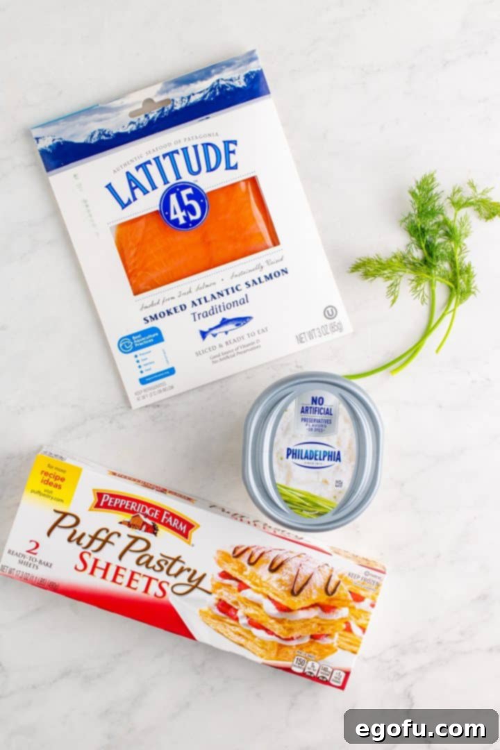 The four main ingredients laid out: smoked salmon, fresh dill, whipped chive cream cheese, and a puff pastry sheet.