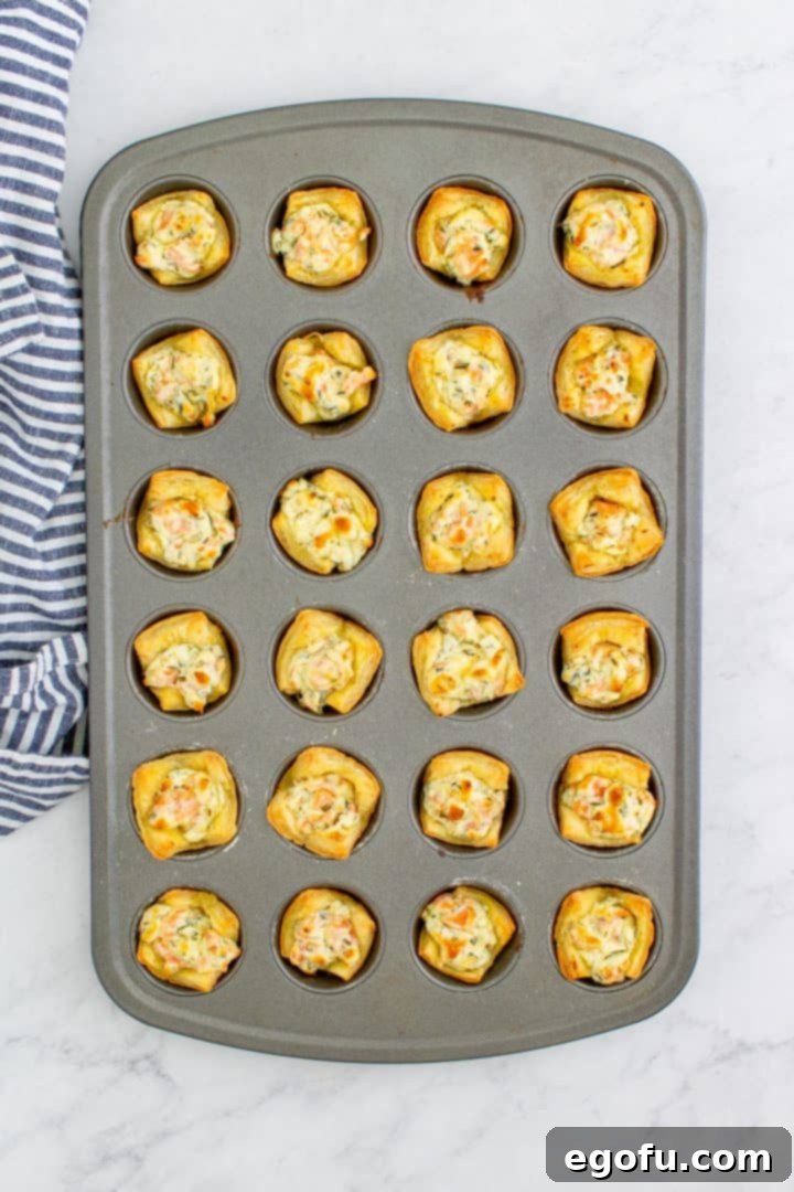 Finished baked Smoked Salmon Puff Pastry Bites still in the mini muffin tin, golden and puffed to perfection.