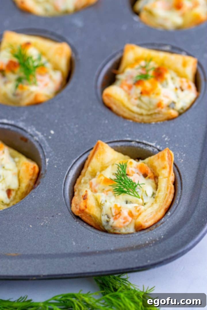 A close-up of the finished Smoked Salmon Puff Pastry Bites cooling gracefully in the muffin tin.