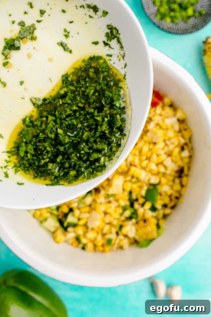 Vinaigrette being poured over the fresh summer corn salad