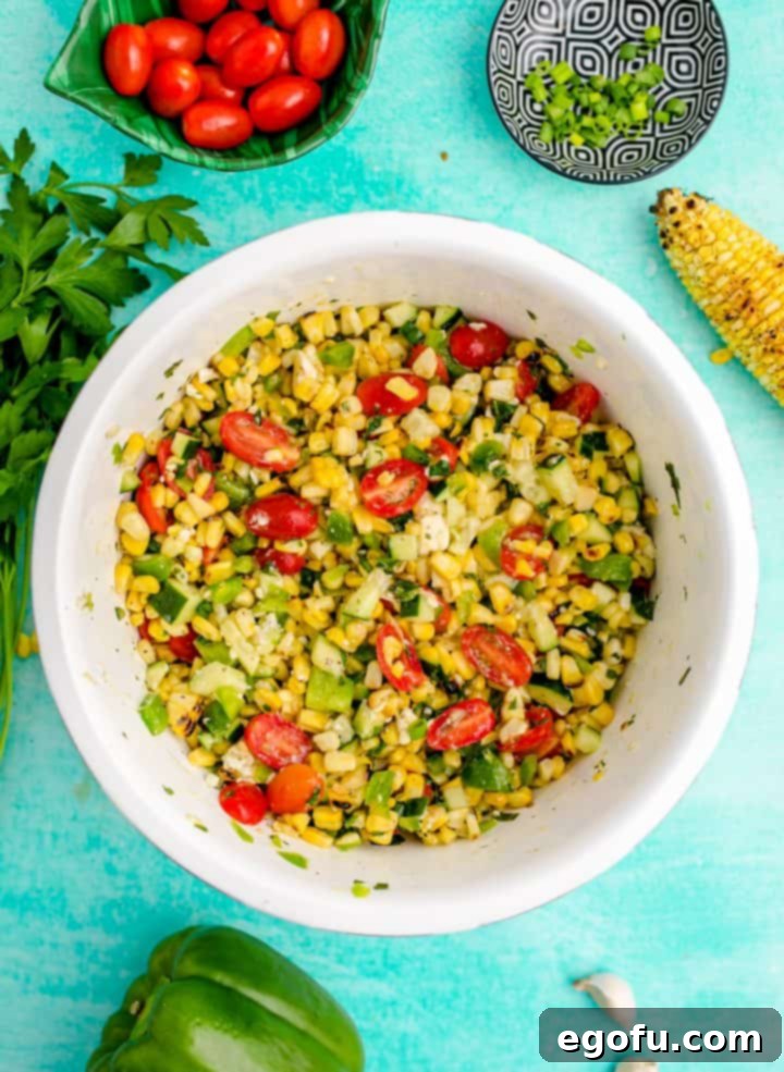 Thoroughly mixed summer corn salad in a white serving bowl