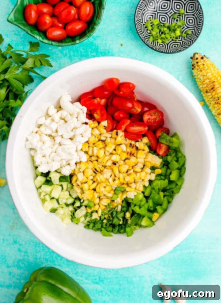 All salad ingredients combined in a white bowl before dressing
