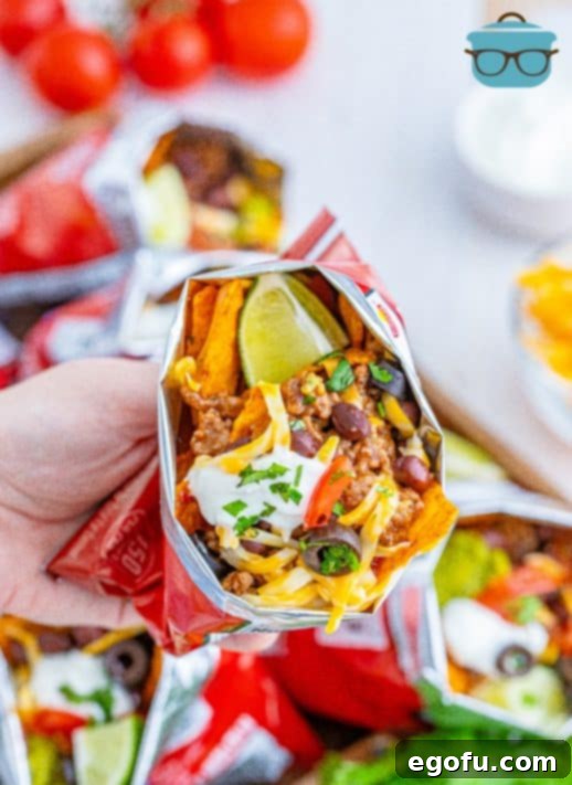 Hand holding one bag of Doritos Walking Tacos showing the inside ingredients