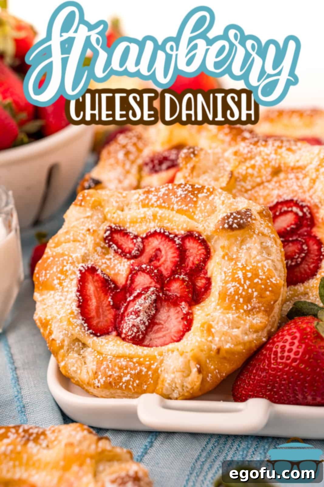 A single Strawberry Cheese Danish, beautifully topped with powdered sugar, ready to be enjoyed. Perfect for a Pinterest image.