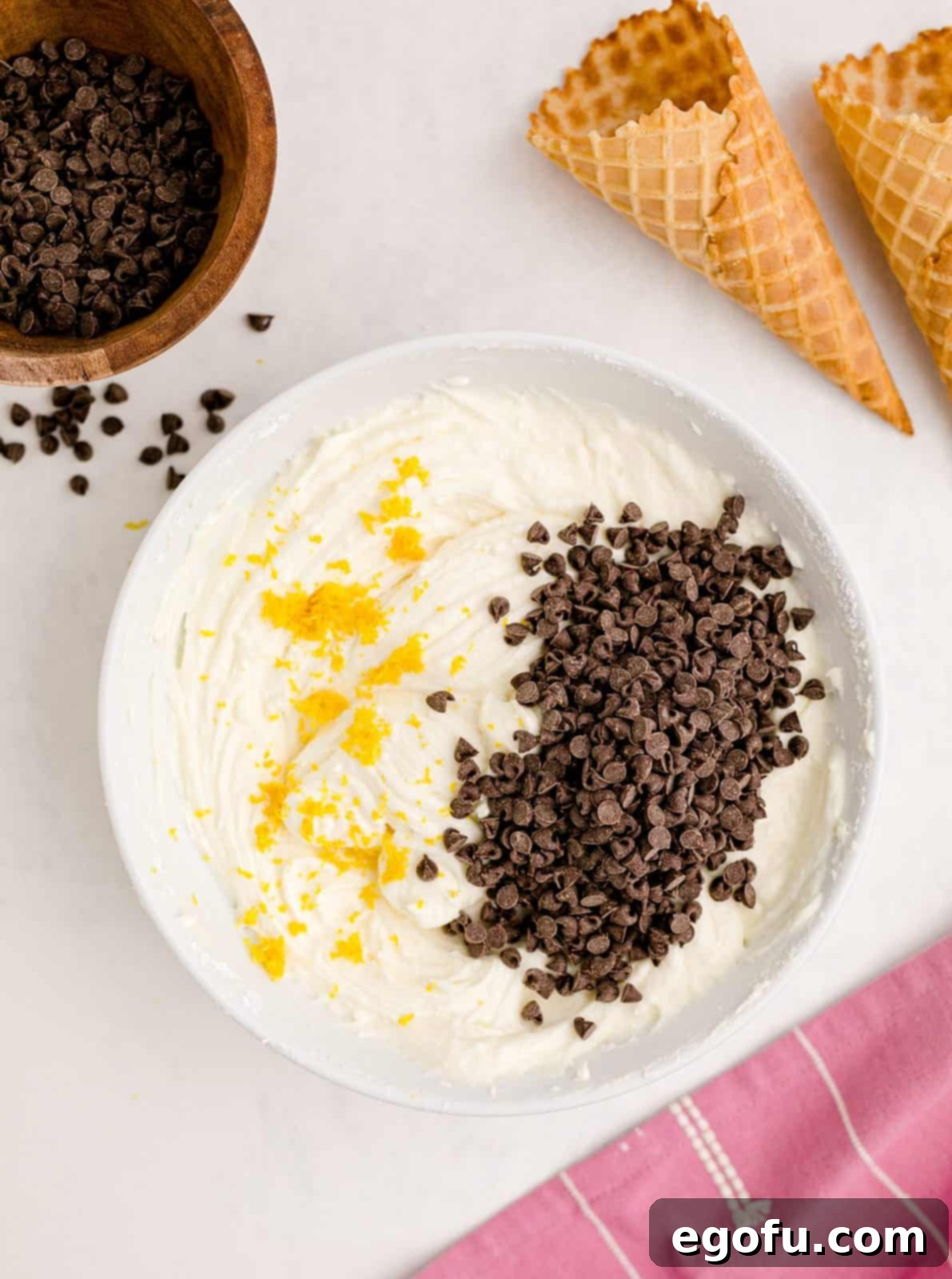 Bright lemon zest and delightful mini chocolate chips freshly added to the creamy beaten cheese and powdered sugar mixture, enhancing the Cannoli Dip.