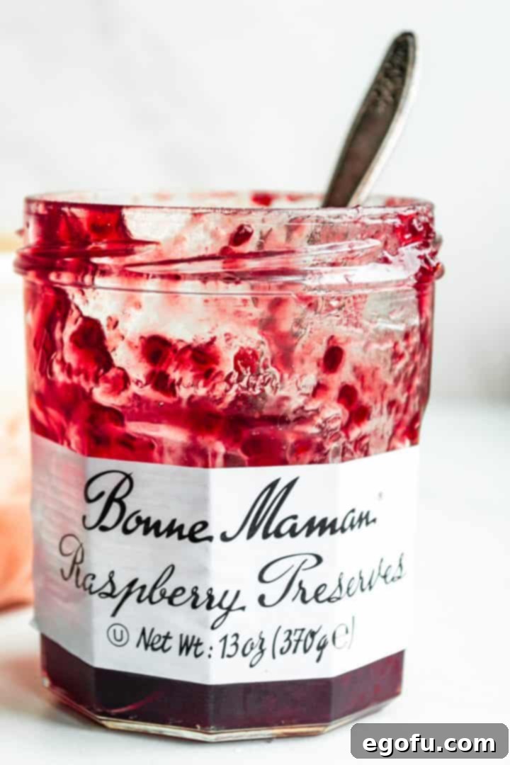The four simple ingredients for Raspberry Honey Butter laid out: unsalted butter, raspberry jam or preserves, honey, and sea salt.