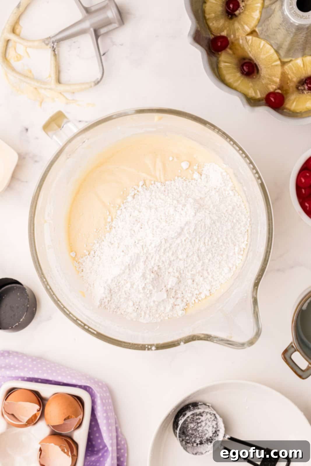 Sunshine Pineapple Bundt Cake 12 Evaporated milk, remaining pineapple juice, and the rest of the cake flour added to the batter in the mixing bowl.