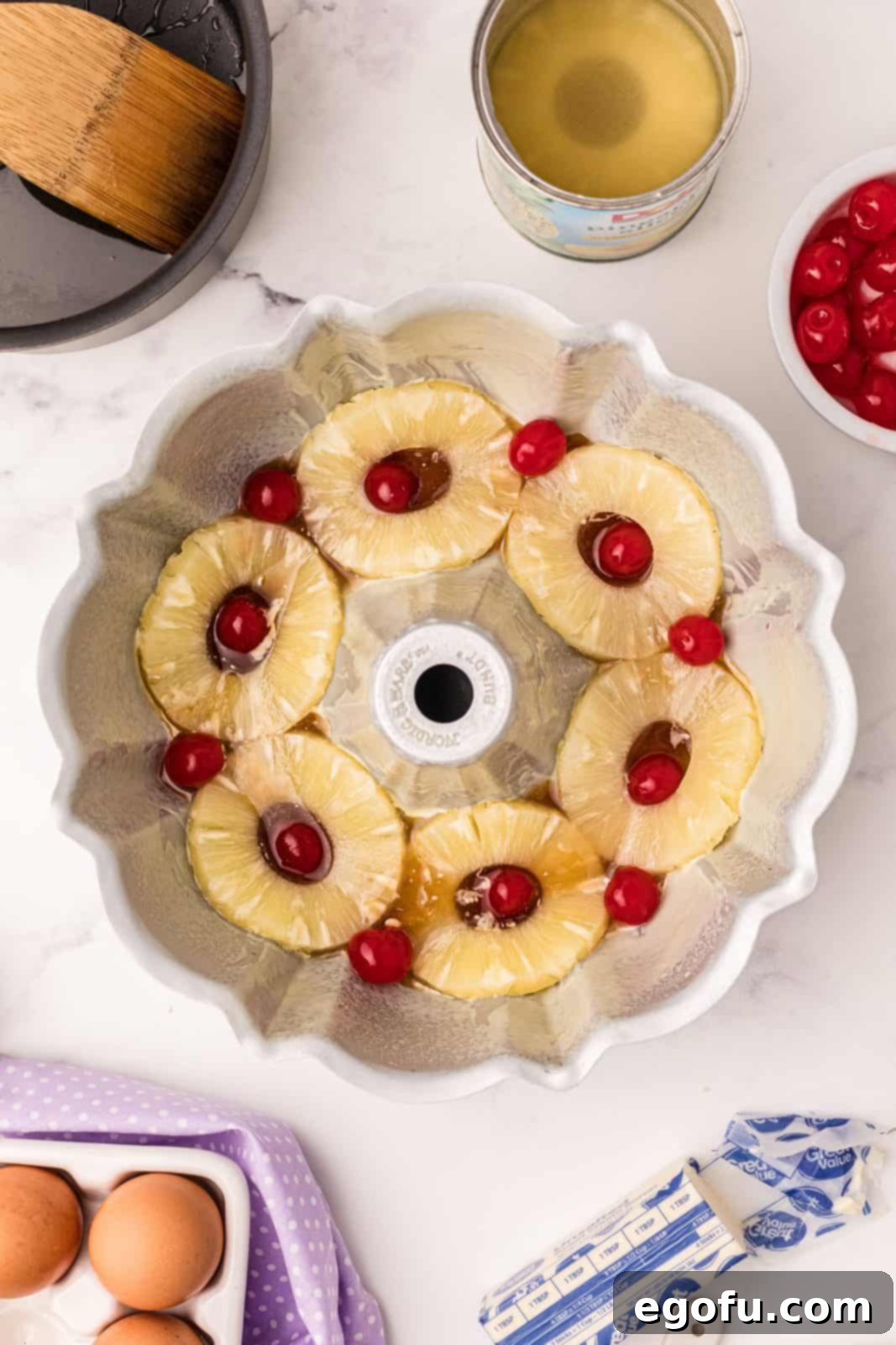 Sunshine Pineapple Bundt Cake 7 Pineapple rings and maraschino cherries neatly arranged in the bundt pan over the caramel topping.