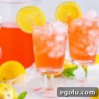 Square image of two glasses of Homemade Pink Lemonade garnished with lemon