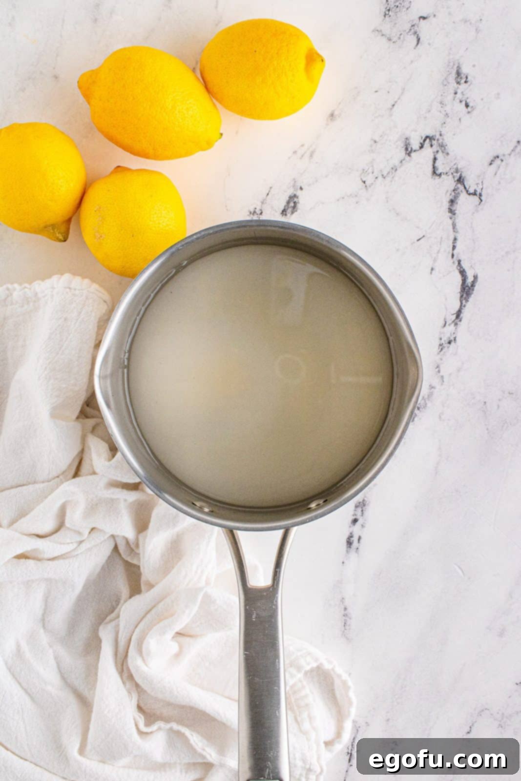 Water and sugar added to a saucepan, ready to be heated.