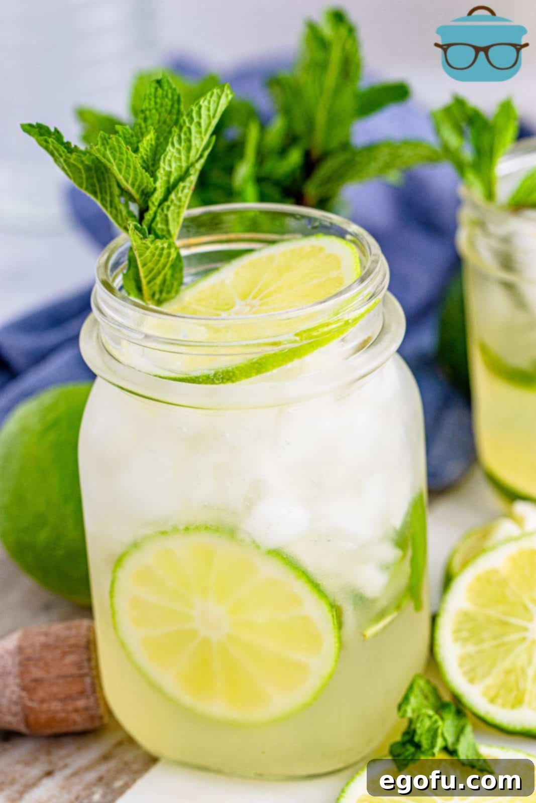 A refreshing Summer Mojito cocktail served in a glass, garnished with fresh mint leaves and lime wedges, ready to be enjoyed.
