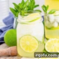 Square image of Mojito in glass garnished with mint and lime