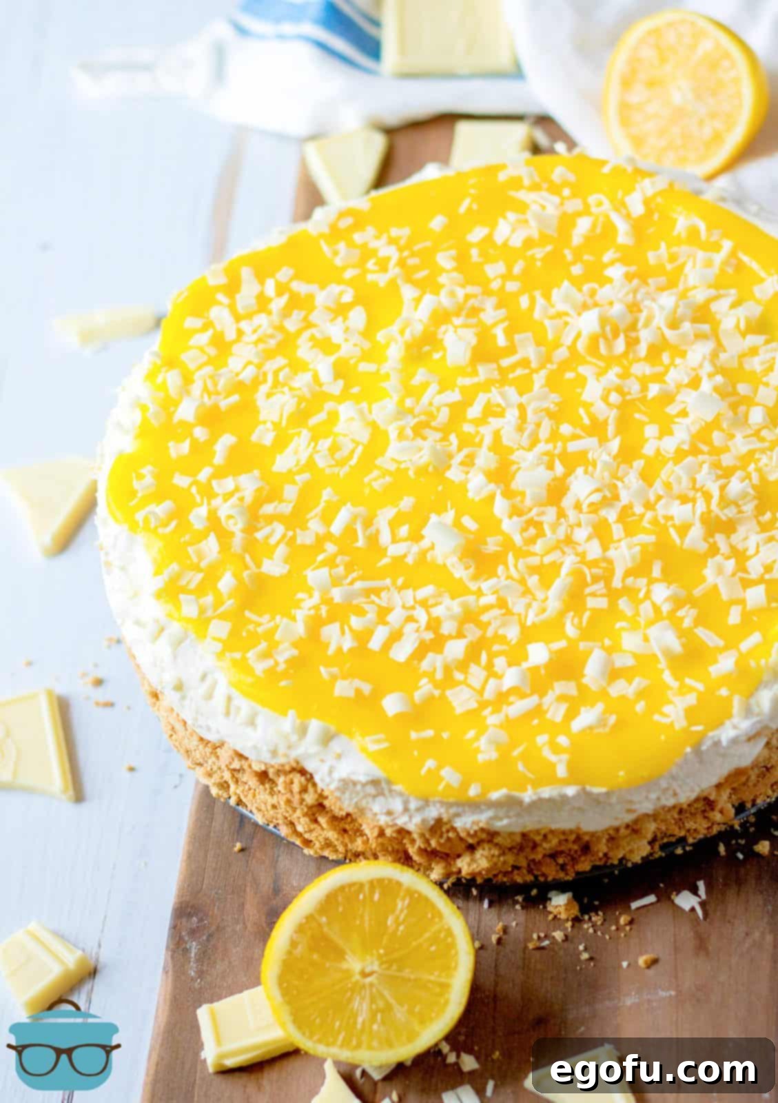 Finished No-Bake Lemon White Chocolate Cheesecake on board with lemon garnish.