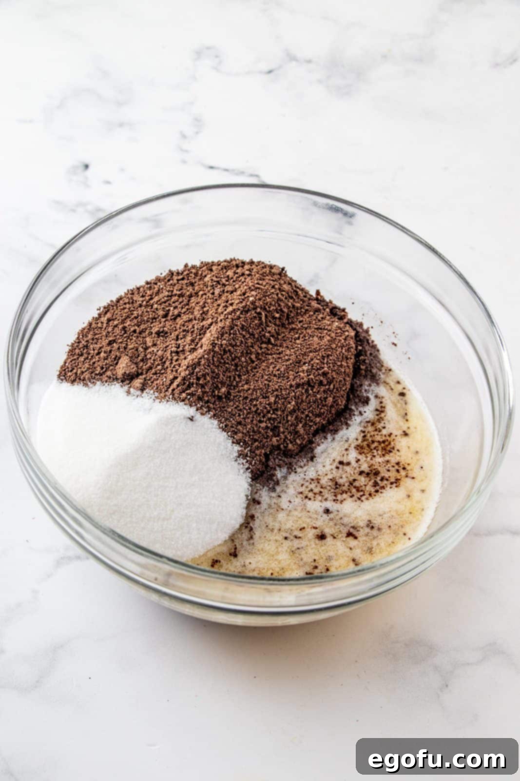 Graham cracker crumbs, sugar and butter in clear bowl.