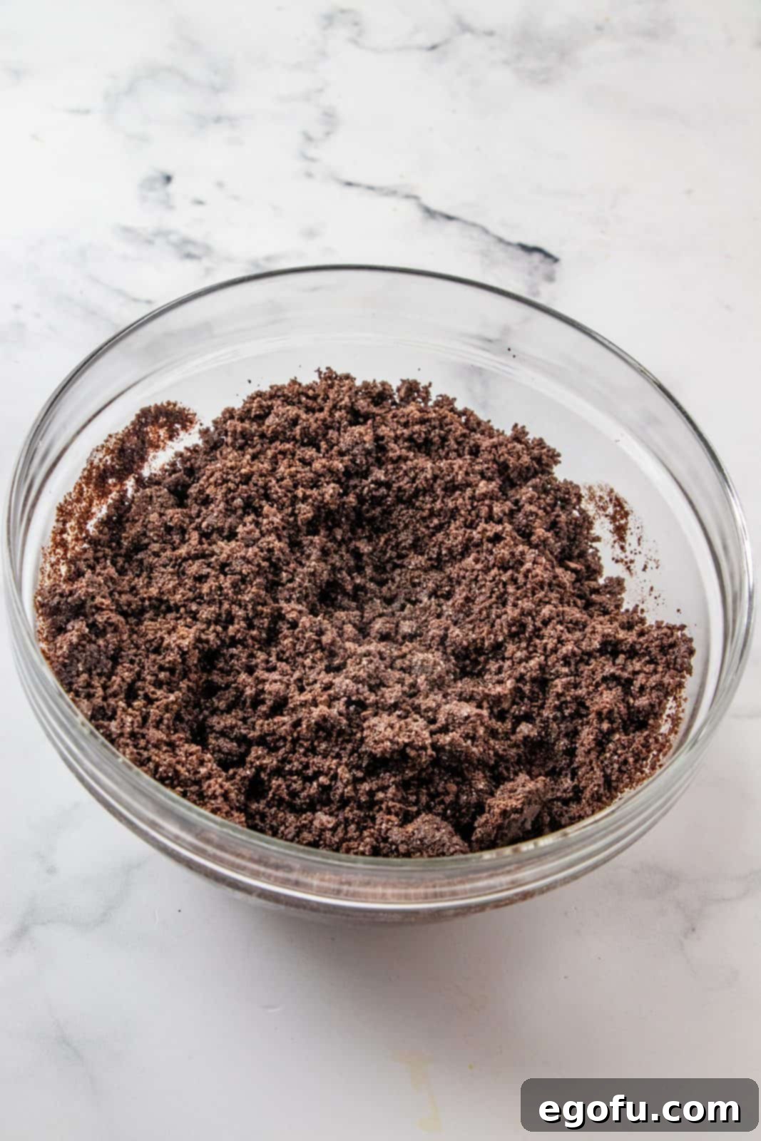 Crumb mixture stirred together in a glass bowl.