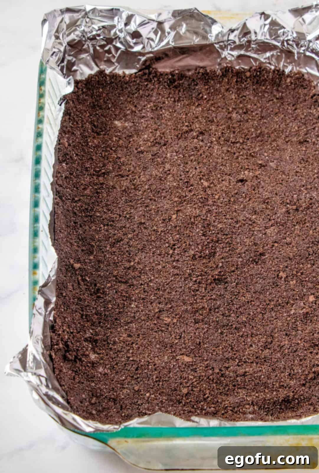 chocolate graham cracker crumb mixture pressed into the bottom of a foil lined pan.