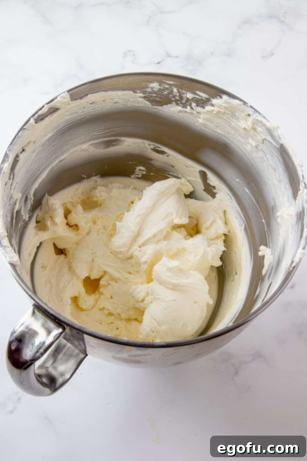 Beaten cream cheese in bowl of stand mixer.